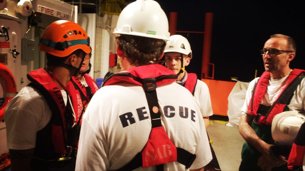 Am Abend bespricht die Rettungsmannschaft, wie sie die Flüchtlinge sicher an Bord geleitet. Andreas Siegert (rechts) hört zu.